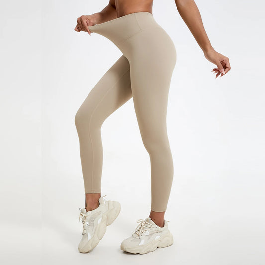 Beige leggings worn by a person on a white background