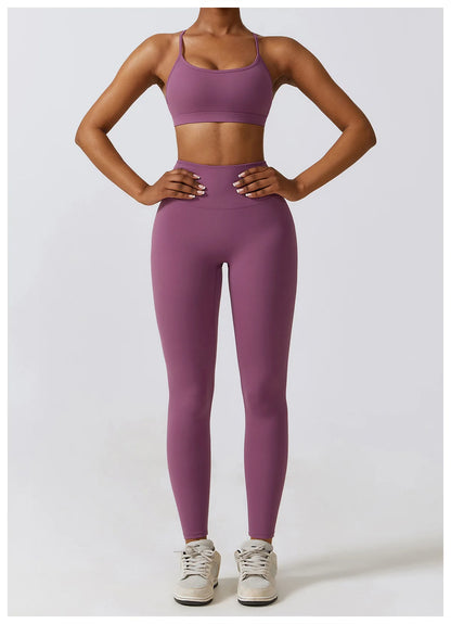 Person wearing a purple sports bra and leggings set on a white background