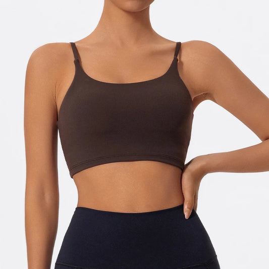 Person wearing a brown sports bra and black leggings on a plain background