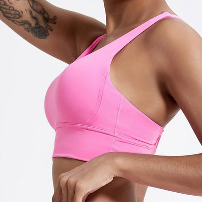 Person wearing a pink sports bra on a plain background