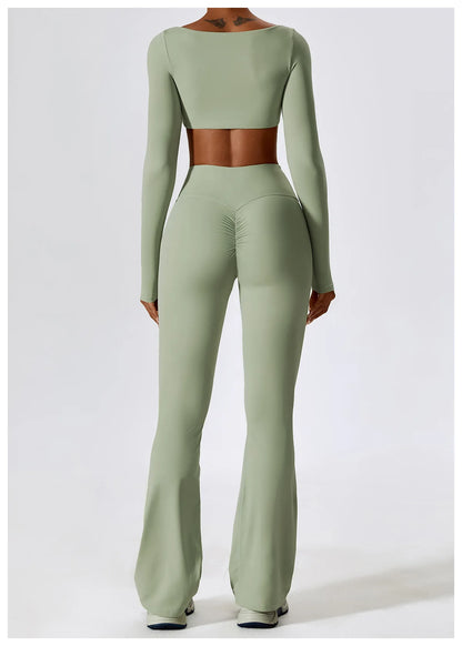 Person wearing a green long-sleeve top and flared pants on a white background