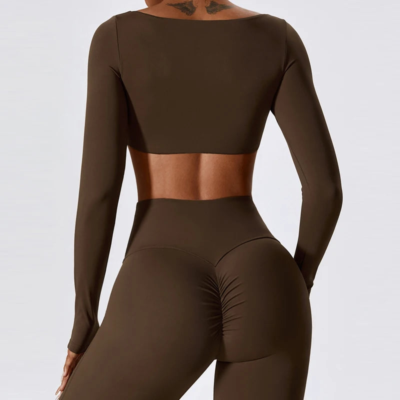 Brown athletic outfit with long-sleeve top and leggings on a plain background