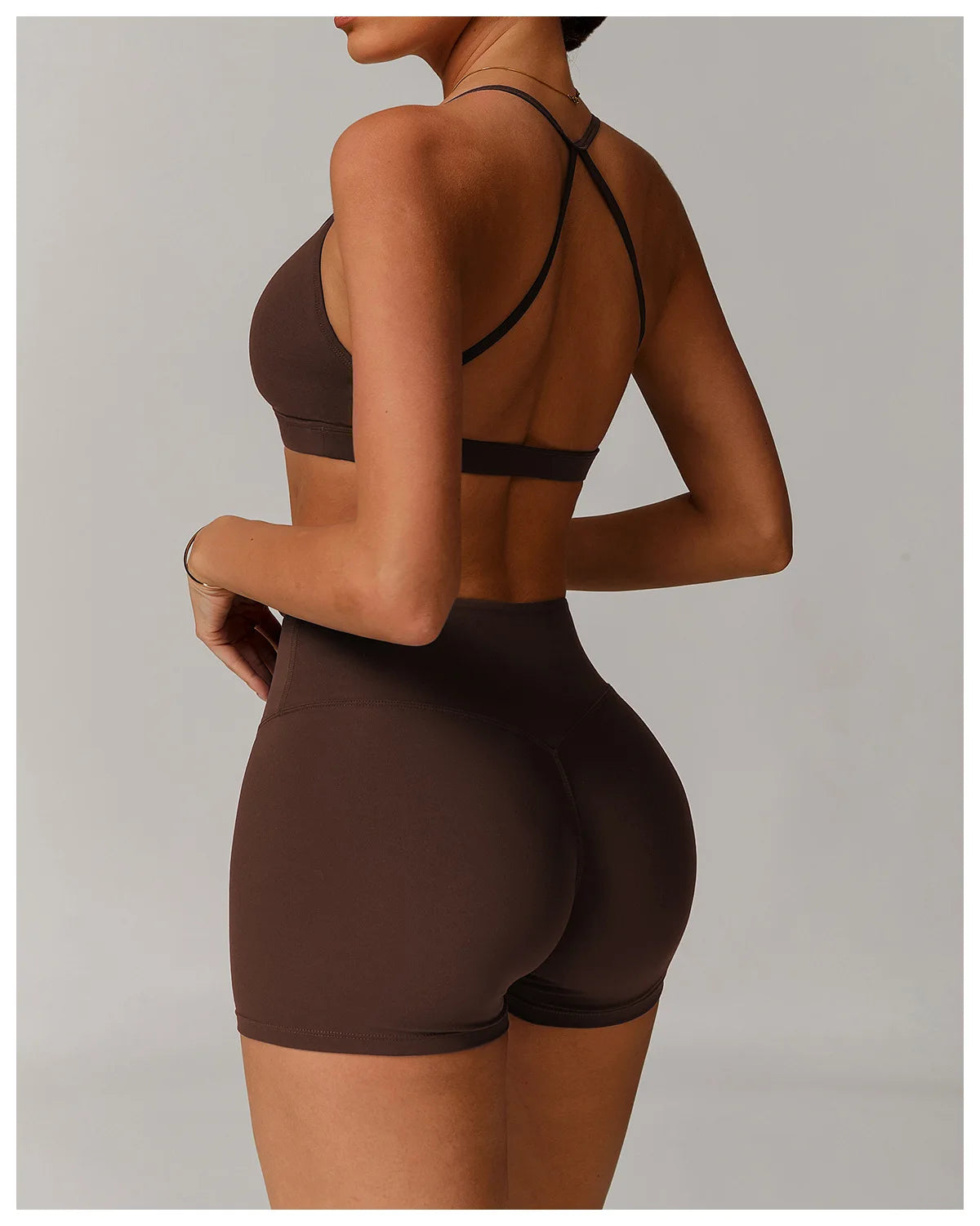 Person wearing a brown sports bra and shorts set on a plain background