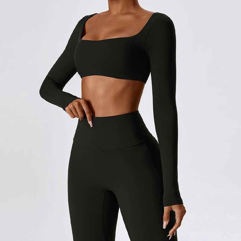 Black long-sleeve crop top and leggings on a plain background