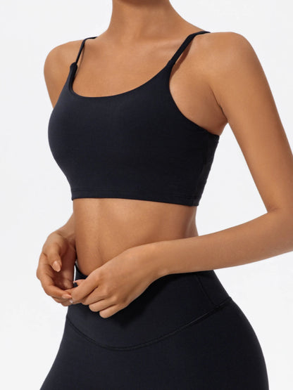 Person wearing a black sports bra and leggings on a plain background