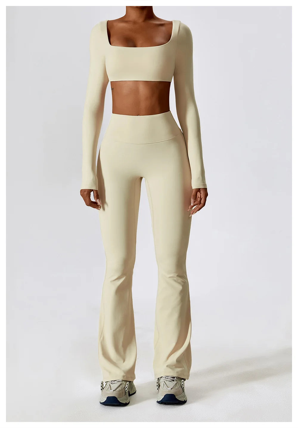 Person wearing a beige long-sleeve crop top and high-waisted leggings on a white background