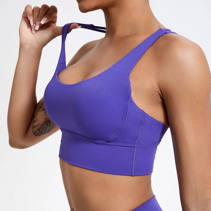 Person wearing a purple sports bra on a plain background
