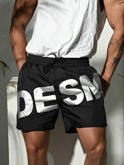 Person wearing black shorts with 'DESM' branding against a neutral background