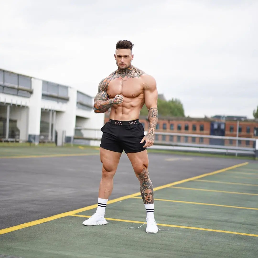 Muscular man with tattoos posing on a sports court